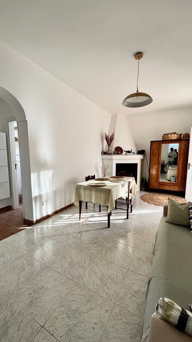 The living room: table by the fireplace, morning sun on the floor
