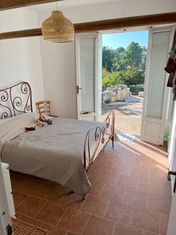 Morning light in the bedroom, doors open to the garden